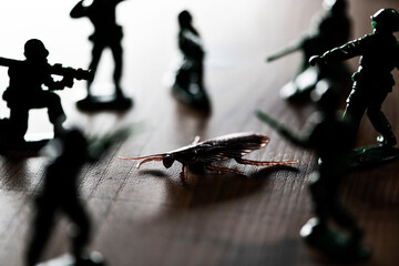 偽物のゴキブリを退治する玩具のミニチュア兵隊