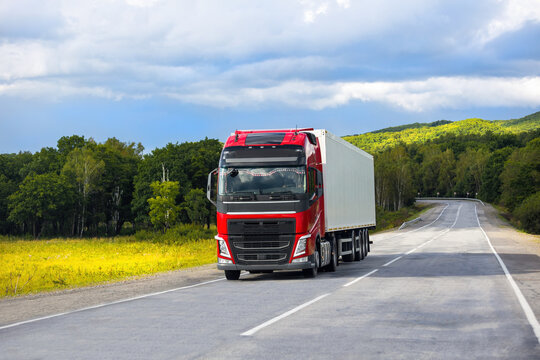 Red truck on a road in summer