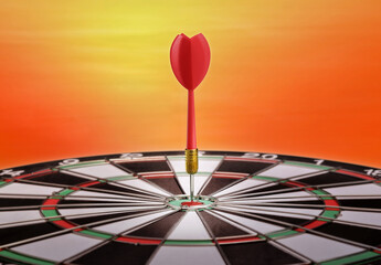 Darts hitting the center of target with sky in the background.