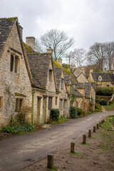 Fototapeta na wymiar Arlington Row in Bibury , classic villages in Cotwolds wonderful stone buildings and river coln during winter cloudy day at Gloucestershire , United Kingdom : 6 March 2018