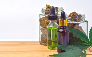 hemp oil bottle Jar of dried marijuana on wooden table, white background. CBD Hemp oil,hemp oil, Medical marijuana products including cannabis leaf, cbd and hash oil, alternative medicine