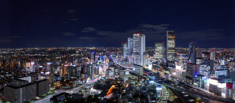 Ultra wide image of Nagoya station and its vicinity downtown area with high rise buildings at night.
