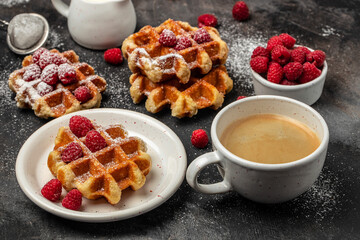 Belgian waffles with raspberries with sugar powder in a freeze motion of a cloud of powder midair, served with jug of milk. Delicious breakfast or snack