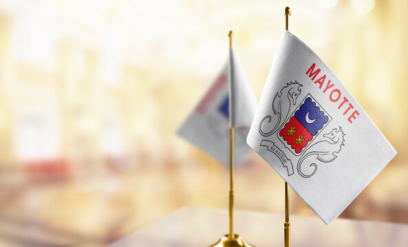 Small flags of the Mayotte on an abstract blurry background - Powered by Adobe