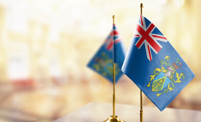 Small flags of the Pitcairn Islands on an abstract blurry background