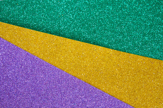 Mardi gras festive traditional color background. Abstract shiny background gold, green, purple. Glow glitter Mardi gras celebration.
