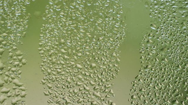 Timelapse water falling by drops through a windows.