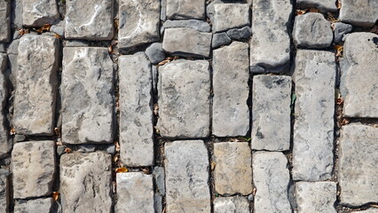 A Wall of old, cracked bricks or stones, with a Weathered Surface. Aged Brick Wall.