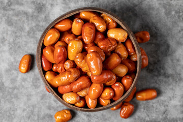 Fresh raw silverberry fruits on dark background. Silverberry in a coconut bowl. Oleaster or russian olive (Elaeagnus). Top view