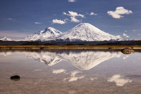 Reflection of the Payachata volcanos on the border of Bolivia and Chile covered in snow 