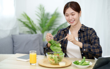 Cheerful young Asian woman happy eating healthy food