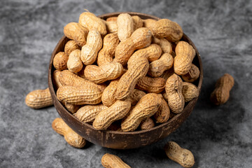 Peanuts in shell on dark background. Peanuts in a coconut bowl. close up