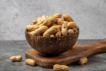Peanuts in shell on dark background. Peanuts in a coconut bowl. close up