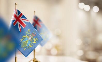 Small flags of the Pitcairn Islands on an abstract blurry background