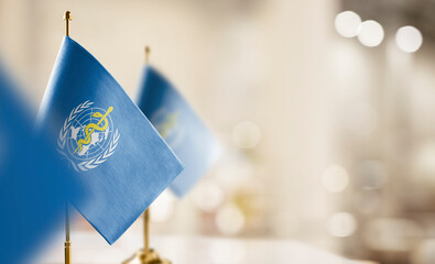 Small flags of the World Health Organization WHO on an abstract blurry background - 558846854