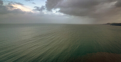 Clouds and rain over the ocean along the Welsh coastal path and coastline. © neil