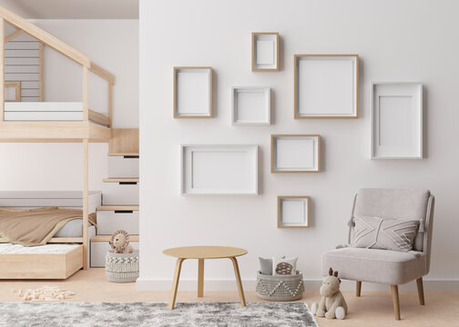 Various empty picture frames on white wall in modern child's room. Mock up interior in contemporary, scandinavian style. Free, copy space for picture. Group of frames. Cozy room for kids. 3D render.