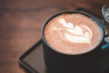 Hot mocha - a cup of hot coffee with beautiful latte art on wooden table background, Morning Breakfast.