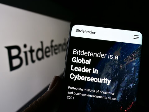 Stuttgart, Germany - 12-30-2022: Person holding cellphone with website of Romanian cybersecurity company Bitdefender on screen in front of logo. Focus on center of phone display.