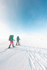 Fototapeta na wymiar two tourists in winter mountains on snowshoes