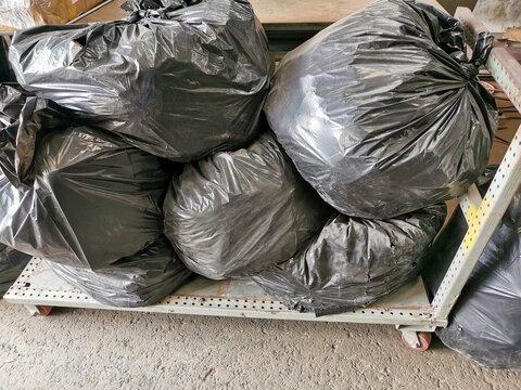 Huge amounts black garbage bags on the factory floor.