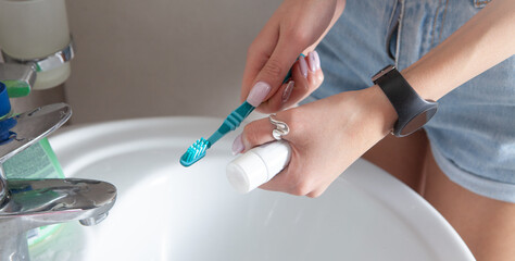 Young woman holding toothbrush before brushing teeth.