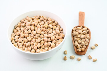 Closeup view of chickpeas in a bowl on a white background.
