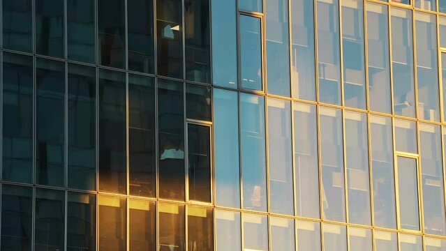 4K time lapse video with the shadows and light moving on the facade of an modern glass office skyscraper building