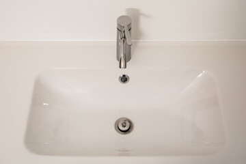 Fototapeta premium White bathroom sink with chrome faucet. Hygiene