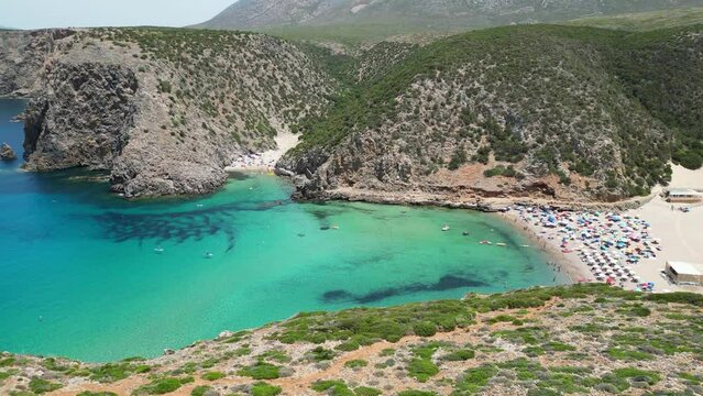 Cala Domestica Beach and Turquoise Blue Cove in Sardinia, Italy - 4k Aerial Tilting Down