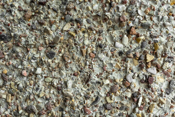 Small stones cemented for decoration and construction. Home facade texture. Rough surface. Grunge grain. Crushed rocks in the wall. Exterior home decoration. Stucco wall pattern