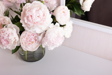 floral de-focused background with a bouquet of light peonies on the dressing table