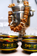 Russian tradition samovar with bagels and Russian folk Khokhloma dishes with jam on the table.