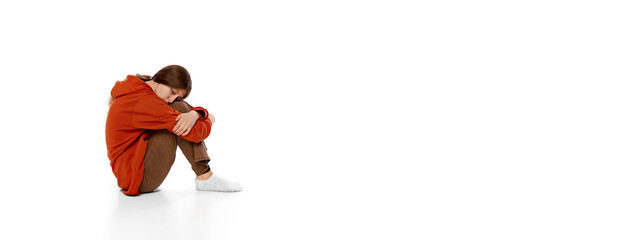 Portrait of teen girl sitting on floor over white background. feeling stressful, sad, depressed and...