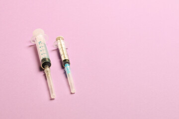 Top view of syringes in a row for medical injection on colorful background with copy space. Health and vaccination concept