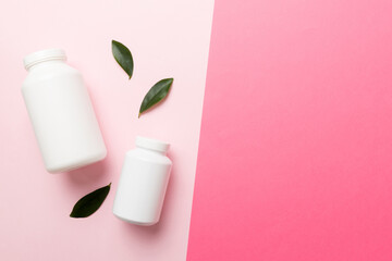 supplement pills with medicine bottle health care and medical top view. Vitamin tablets. Top view mockup bottle for pills and vitamins with green leaves, natural organic bio supplement, copy space