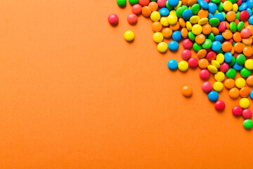 Obraz premium Mixed collection of colorful candy, on colored background. Flat lay, top view. frame of colorful chocolate coated candy