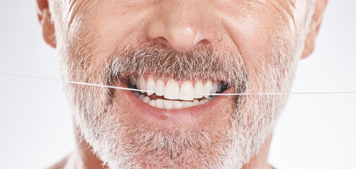 Dental, floss and mouth of senior man in studio isolated on a gray background. Hygiene, cleaning...