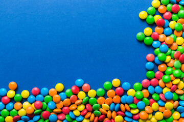 Mixed collection of colorful candy, on colored background. Flat lay, top view. frame of colorful chocolate coated candy