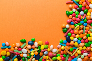 Fototapeta na wymiar Mixed collection of colorful candy, on colored background. Flat lay, top view. frame of colorful chocolate coated candy