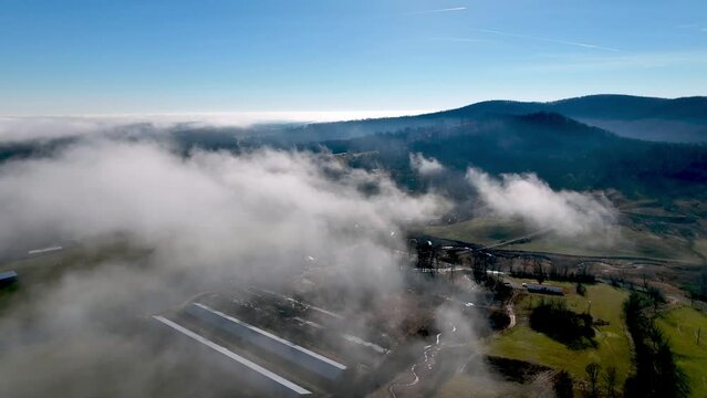 Clouds over the valley below the brushy mountains in wilkes county nc, north carolina with Chicken farm below