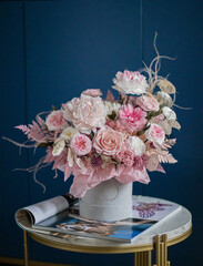 Beautiful flowers. Beautiful flower arrangement in a box on dark blue background on coffee table....