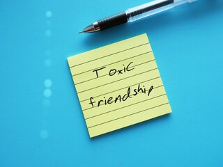 Pen writing on note pad TOXIC FRIENDSHIP, refers to friends who leave negative effects - mentally...
