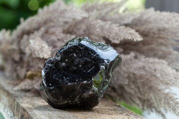 Black Obsidian Mineral Rock Sample over Wood