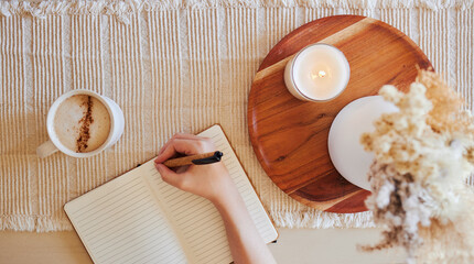 Coffee, hand and writing in journal top view with candle for calm, peace and relax morning routine....