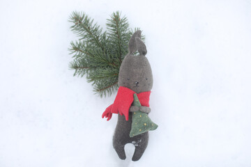 Black toy rabbit as symbol 2023 on white snow background. Christmas and Happy New Year concept....