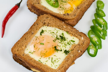 Open sandwiches with fried eggs on dish, fragment in selective focus