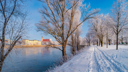 Panoramic view over Magdeburg historical downtown in Winter with icy trees and snow during sunrise in the morning with warm illumination and blue sky, Germany.