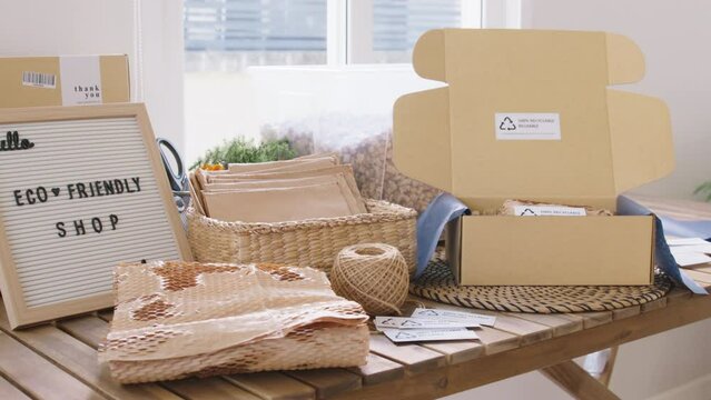Net zero waste go green SME use eco friendly care sign plastic free symbol packaging carton box wrap paper in small shop retail store. Chva dried water hyacinth on desk reuse packing parcel supplies.
