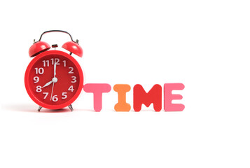 Red alarm clock showing eight morning and the word time consisting multicolored letters white background.